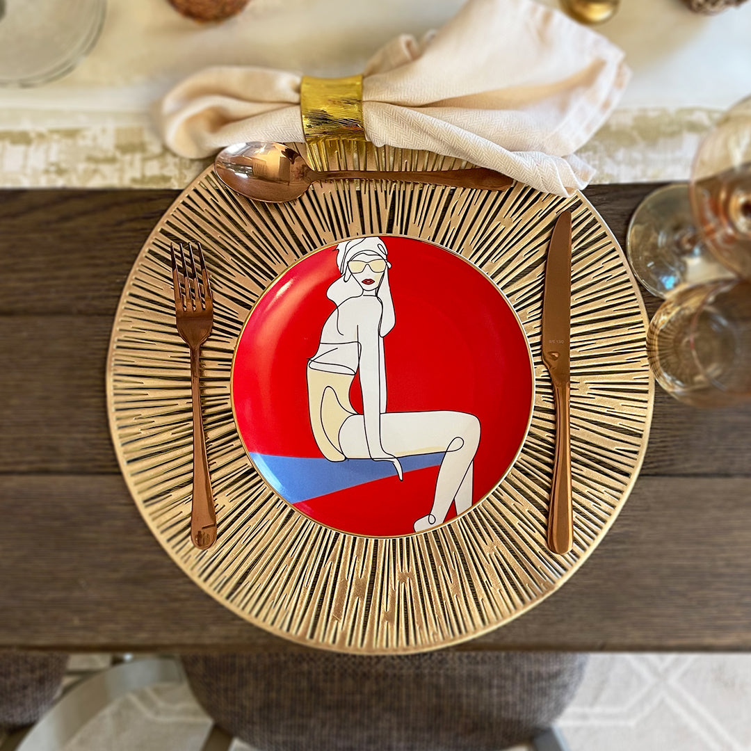 Aerial view of a Red Salad Plate with 24K Gold rim with an image of a confident girl sitting on a ledge set up beautifully on a table with fork, spoon and knife.