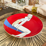 Angle view of a Red Salad Plate with 24K Gold rim with an image of a confident girl sitting on a ledge set up beautifully on a table.